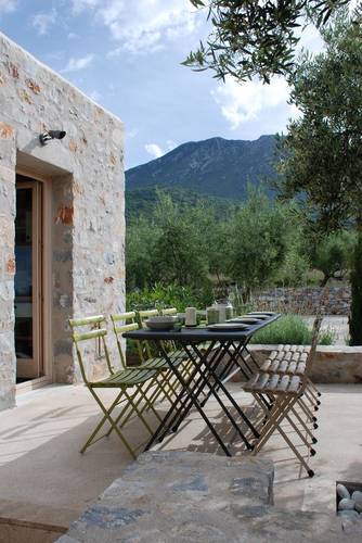 The outdoor dining table under the olive trees