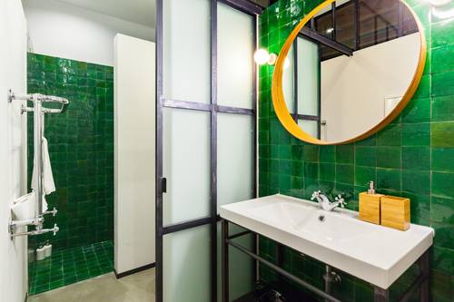 The bathroom carries the green-tiled theme throughout